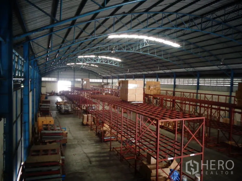货栈 出租或出售在Lat Lum Kaeo, Pathum Thani - 俯视多排货架与拱形采光屋顶的仓储大厅。