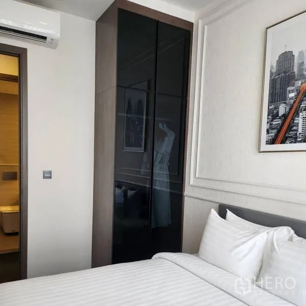 公寓 出租在Watthana, Bangkok - 卧室设有嵌入式衣柜，门通套内卫浴。