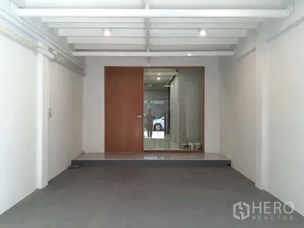 Shophouse for rent in Phra Khanong, Bangkok - Open showroom on the ground floor with a glass partition and wooden door facing the street.