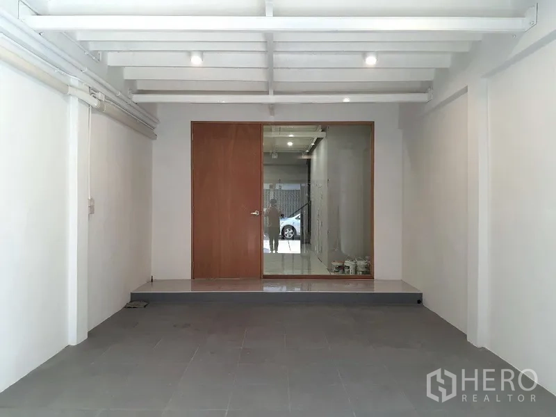 Shophouse for rent in Phra Khanong, Bangkok - Open showroom on the ground floor with a glass partition and wooden door facing the street.