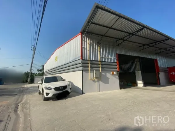 คลังสินค้า ให้เช่าในLam Luk Ka, Pathum Thani - โกดังผนังเมทัลชีท หลังคาสูง มีชายคาโหลดสินค้า ประตูม้วนกว้าง และลานคอนกรีตในลำลูกกา