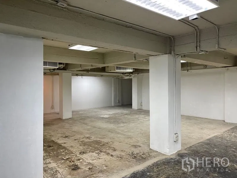 Office Space for rent in Ratchathewi, Bangkok - Spacious office floor with structural columns, white walls and visible conduits.