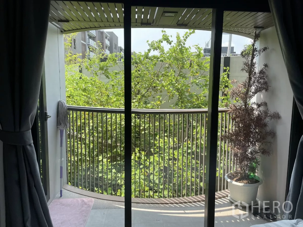 公寓 出租在Watthana, Bangkok - 私家阳台，弧形栏杆，眺望繁茂绿树。