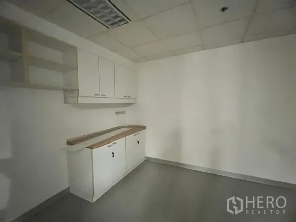 Office Space for rent in Khlong Toei, Bangkok - Office pantry with built-in white cabinets, countertop and shelving.