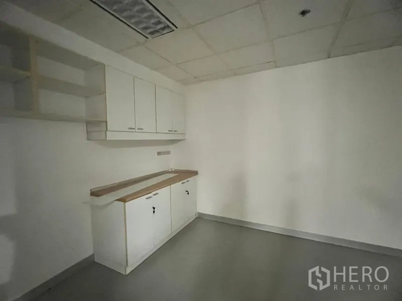 Office Space for rent in Khlong Toei, Bangkok - Office pantry with built-in white cabinets, countertop and shelving.