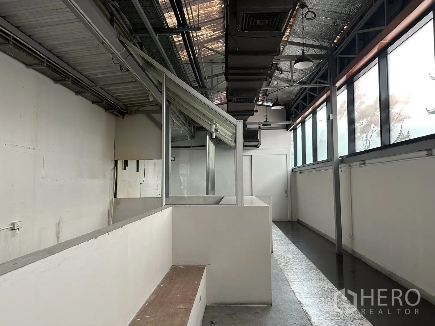 Retail Space for rent in Bang Rak, Bangkok - Narrow aisle with exposed ducting, suspended lights and strip windows.