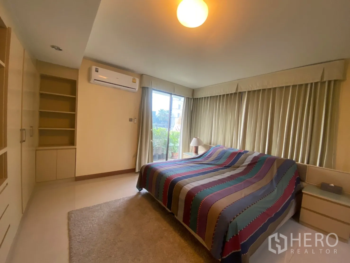 Condominium for rent in Phaya Thai, Bangkok - Spacious master bedroom with king bed, wall-to-wall windows, and balcony access.