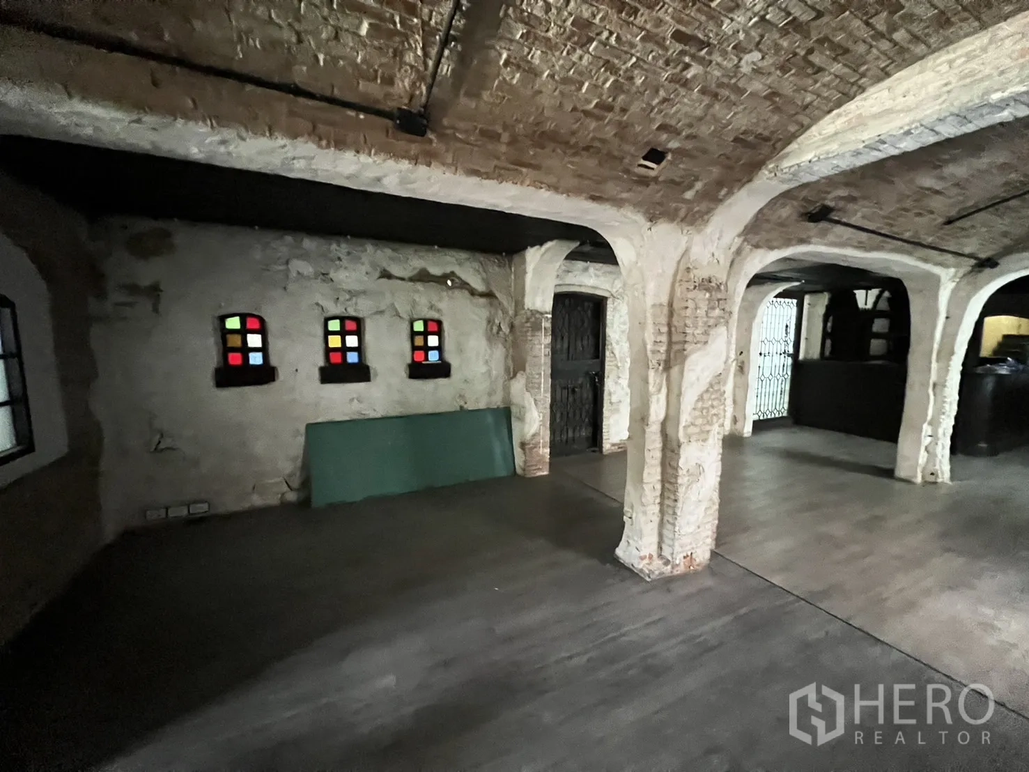 Retail Space for rent in Watthana, Bangkok - Spacious hall with rustic brick columns, vaulted ceiling and small colorful stained-glass windows.