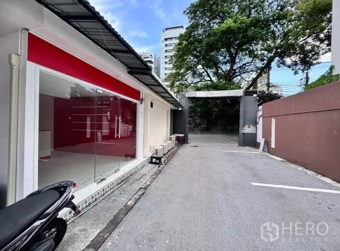 Retail Space for rent in Watthana, Bangkok - Street-facing retail unit with full glass storefront and gated driveway in the Thonglor area of Watthana, Bangkok.