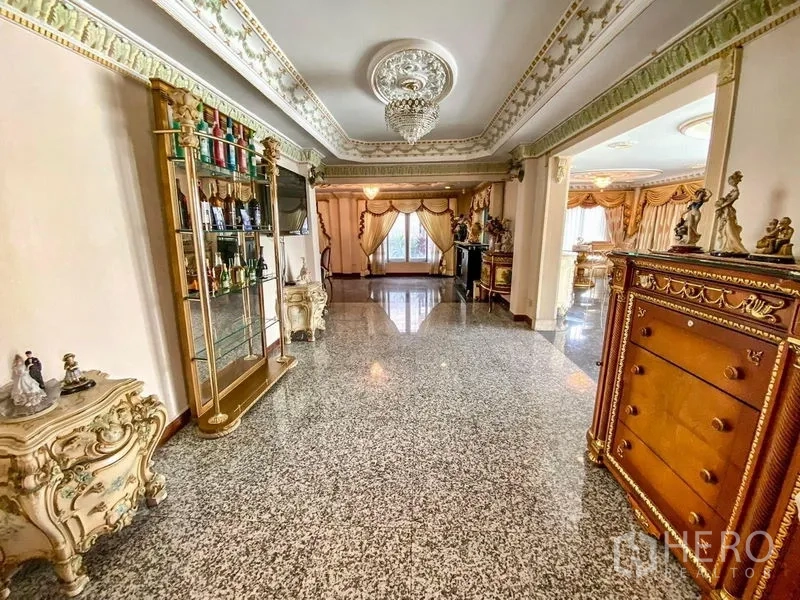 Detached House for rent or sale in Bang Khen, Bangkok - Wide hall with polished stone flooring, chandelier lighting, and classic decorative moldings.