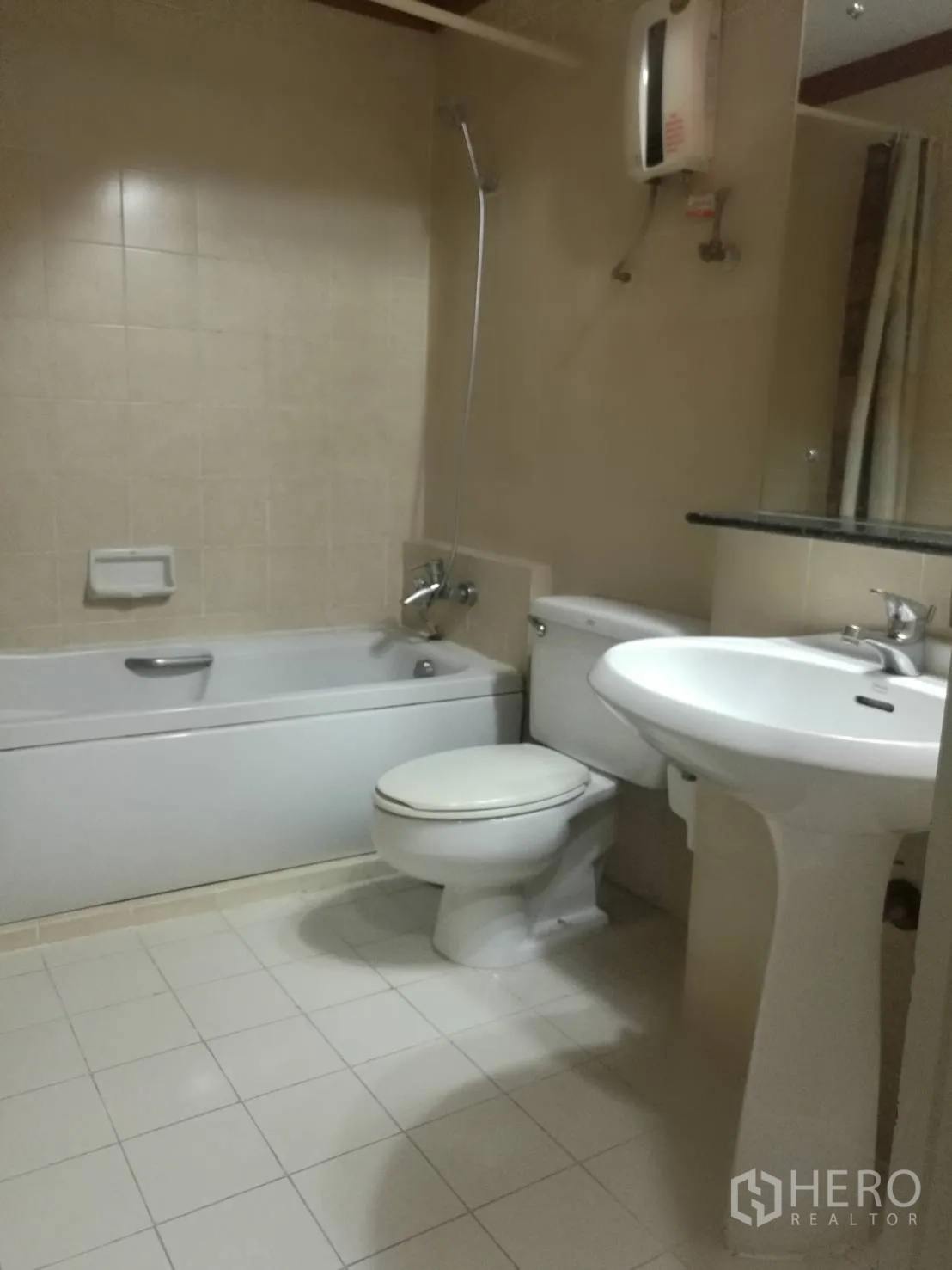 Condominium for rent in Khlong Toei, Bangkok - Bathroom with bathtub, shower, pedestal sink and water heater.