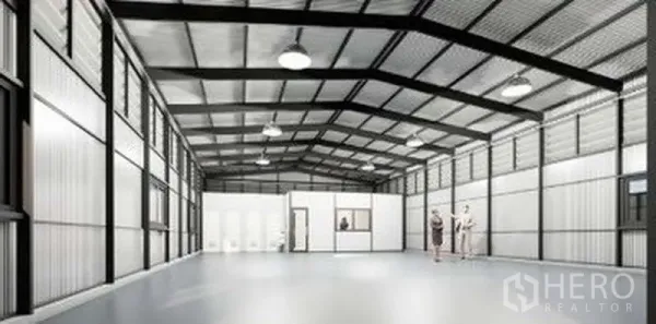 Warehouse for rent in Lat Phrao, Bangkok - Open-plan storage hall with built-in office rooms, restrooms, side windows and a polished concrete floor.