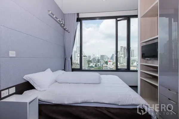 公寓 出租在Watthana, Bangkok - 卧室配大幅景观窗，俯瞰素坤逸天际线。
