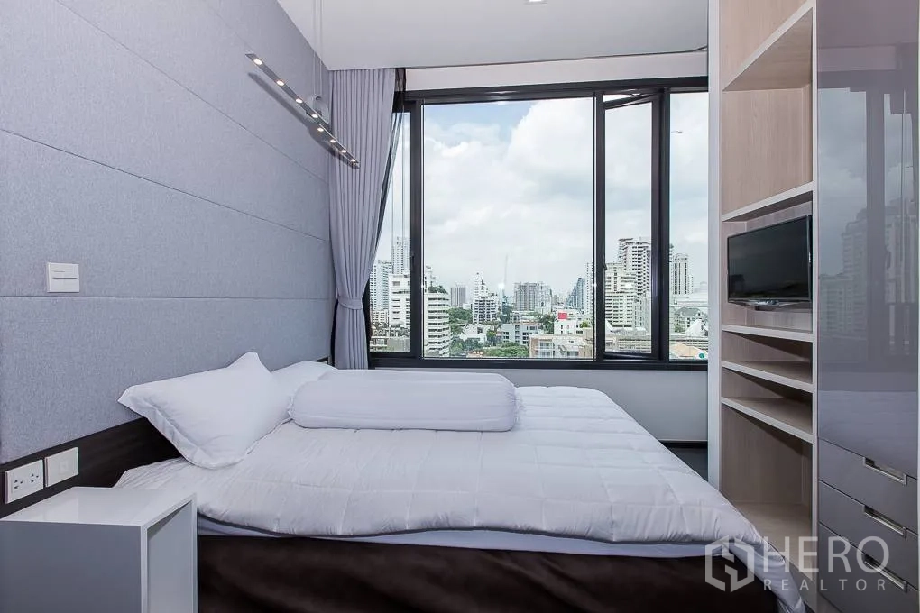 公寓 出租在Watthana, Bangkok - 卧室配大幅景观窗，俯瞰素坤逸天际线。