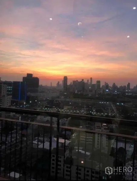 Condominium for sale in Khlong Toei, Bangkok - High-floor balcony view of Bangkok skyline at sunset from a Khlong Toei condo.