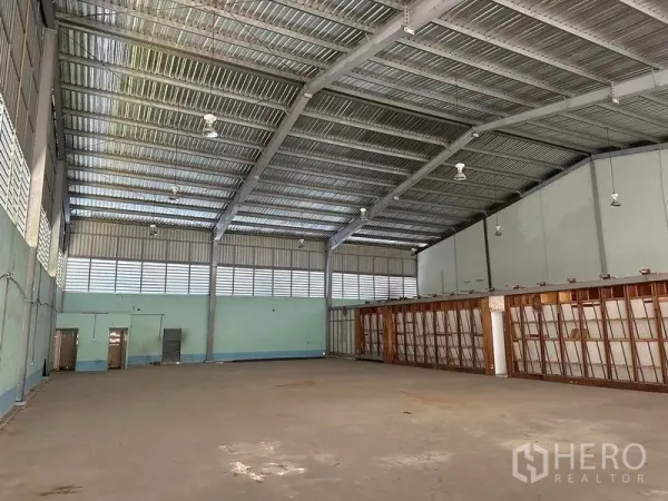 Warehouse for rent in Lam Luk Ka, Pathum Thani - High-clearance warehouse with steel truss roof, vents, and open storage floor.