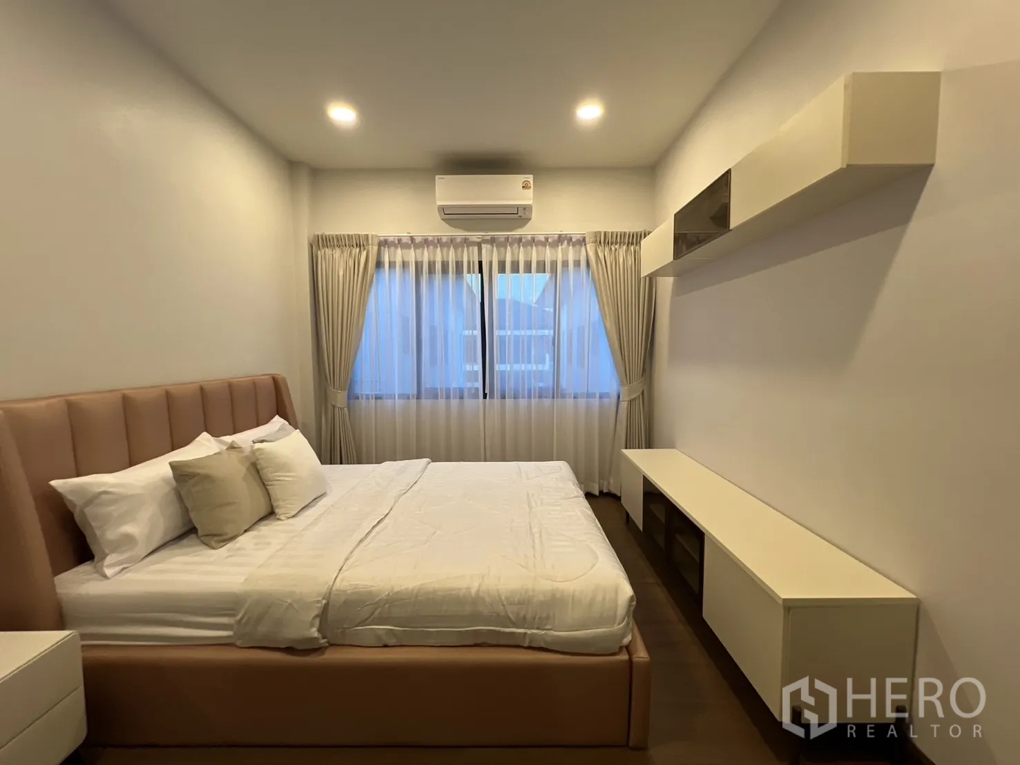 Detached House for rent in Bang Phli, Samut Prakan - Guest bedroom with upholstered bed, curtains and floating shelves.