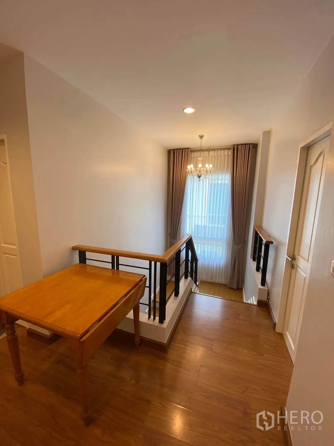 独栋房屋 for rent in Mueang Samut Prakan, Samut Prakan - 楼梯平台铺木地板，吊灯优雅明亮。