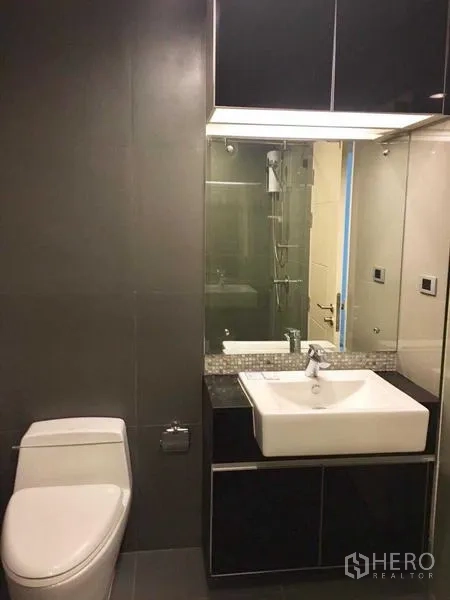 Condominium for rent in Khlong Toei, Bangkok - Second bathroom with vanity sink, mirror cabinet and toilet.