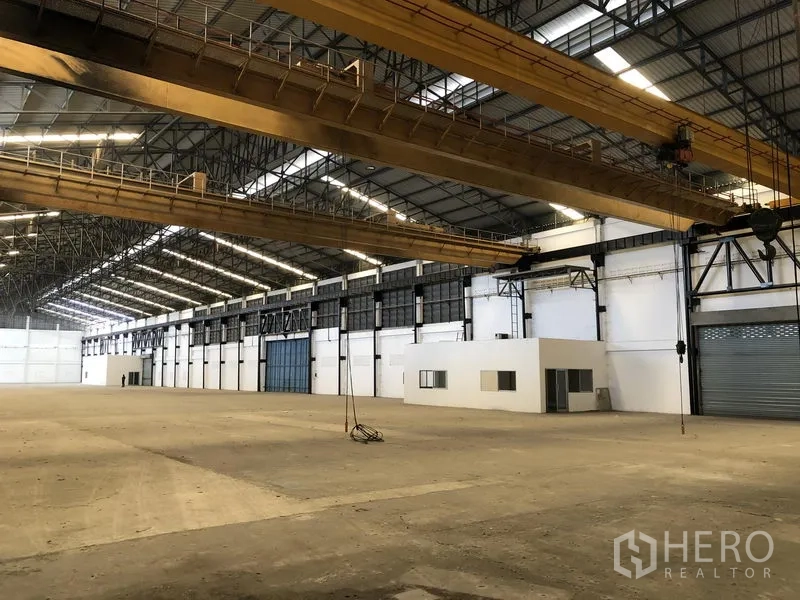 工厂 出租在Mueang Samut Prakan, Samut Prakan - 侧视厂房，行车、卷帘门与办公室一并可见。