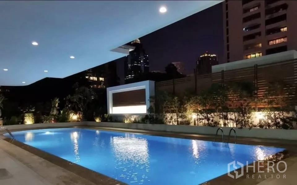 公寓 出租在Pathum Wan, Bangkok - 夜景泳池，城市天际线为背景。