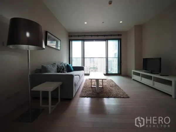 คอนโด ให้เช่าในWatthana, Bangkok - ห้องนั่งเล่นมีโซฟา ชุดวางทีวี และประตูระเบียงมองเห็นวิวเมือง
