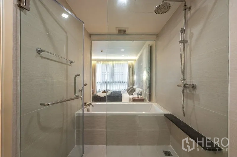 Condominium for sale - Modern bathroom with glass shower, soaking tub and rain shower head.