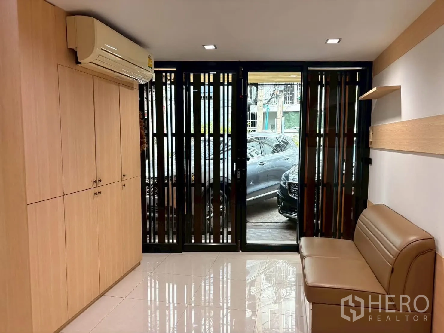 ทาวน์เฮาส์ for rent in Pathum Wan, Bangkok - โถงชั้นล่างพร้อมตู้บิลท์อิน เครื่องปรับอากาศ และประตูกระจกสไลด์ออกสู่ที่จอดรถ.