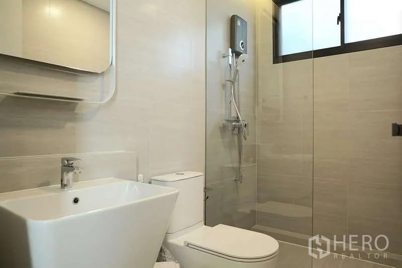 Detached House for rent in Saphan Sung, Bangkok - Modern bathroom with walk-in shower, square basin and wall mirror in neutral tones.