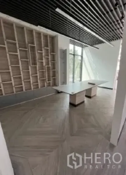 Retail Space for rent in Khlong Toei, Bangkok - Built-in display shelving and long counter beneath slatted ceiling beside a tall window.
