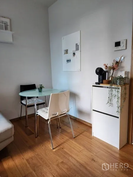 Condominium for rent in Watthana, Bangkok - Cozy dining nook with round glass table, two chairs and a countertop coffee machine.
