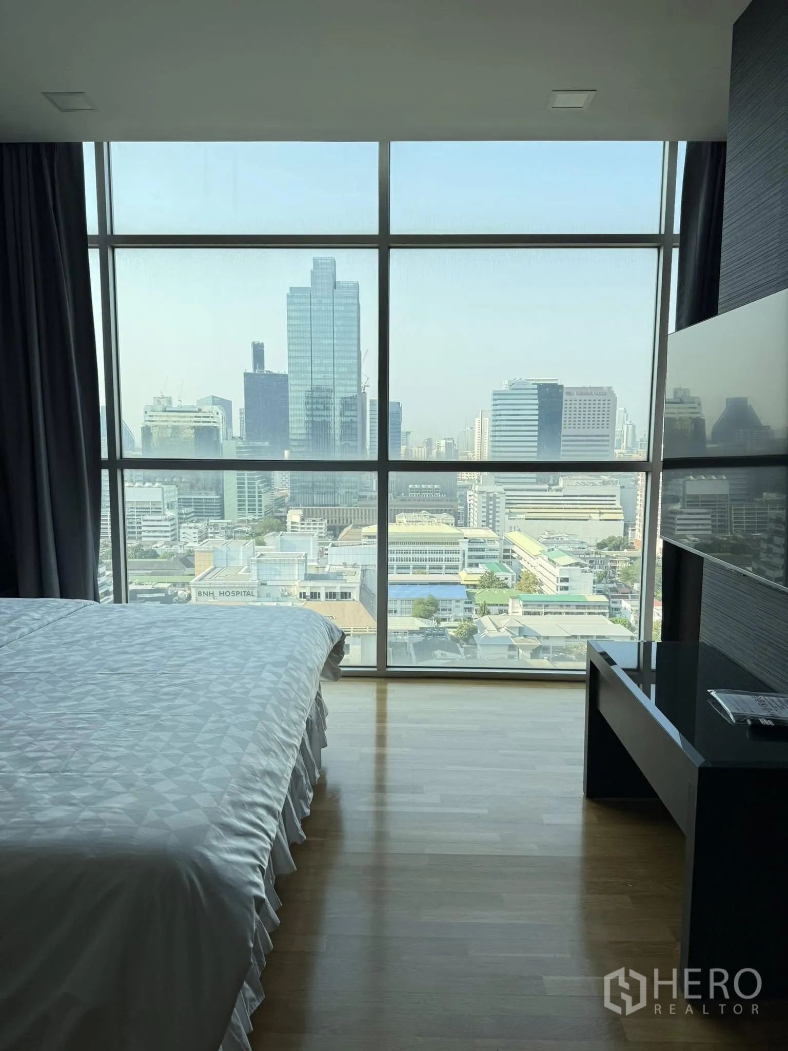 Condominium for rent or sale in Sathon, Bangkok - Bedroom window view of Bangkok skyline with nearby BNH Hospital.