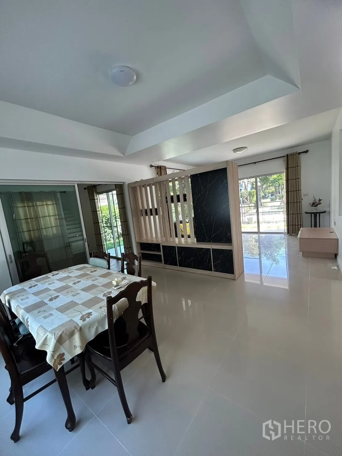 Detached House for rent in Bang Na, Bangkok - Bright dining area with four-seat table, partition wall, and sliding glass doors.
