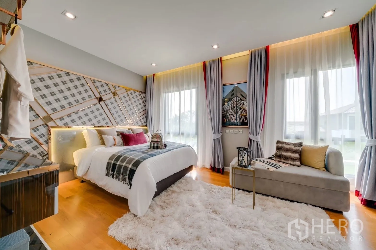 Detached House for rent in Prawet, Bangkok - Bright bedroom with patterned accent wall, chaise lounge and large windows