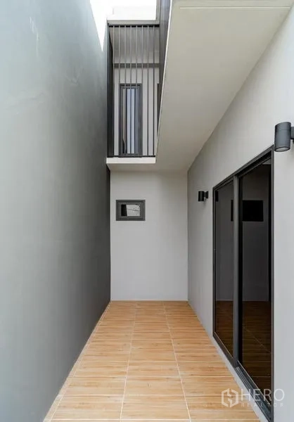 Detached House for sale in Lam Luk Ka, Pathum Thani - Private side terrace with sliding doors and wood-look tiles.