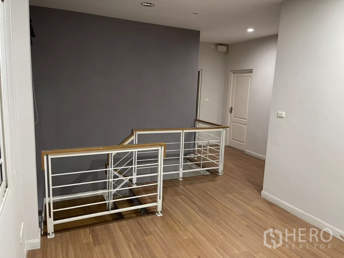 Detached House for rent in Bang Kapi, Bangkok - Upper hallway with modern metal railing and wood floors connecting bedrooms.