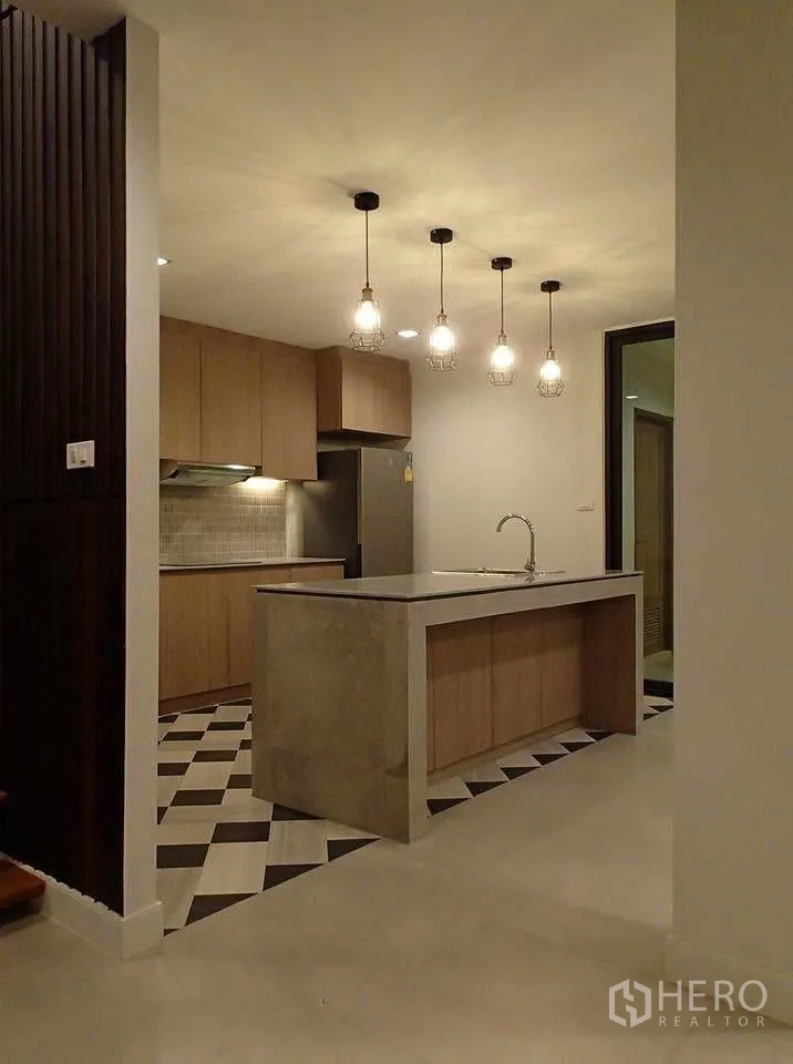 ทาวน์เฮาส์ for rent in Watthana, Bangkok - ครัวพร้อมไอส์แลนด์กลาง โคมไฟแขวน ตู้เย็น และพื้นกระเบื้องลายสลับ