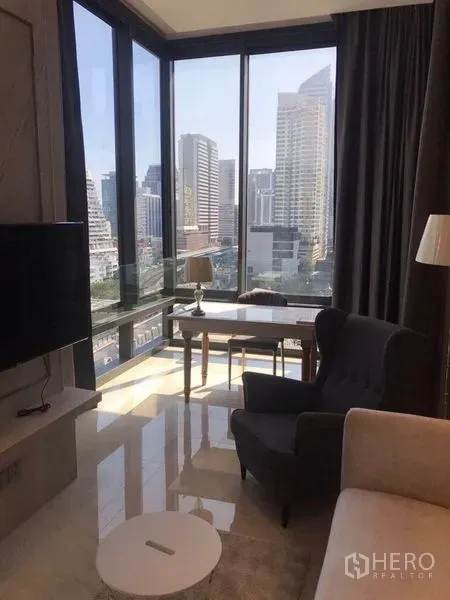 公寓 出租在Bang Rak, Bangkok - 转角客餐厅，通高玻璃与城市天际线景观相伴。