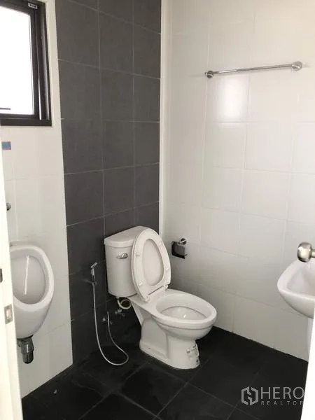 Warehouse for rent or sale in Lam Luk Ka, Pathum Thani - Clean restroom with toilet, urinal, sink and tiled walls inside the office area.