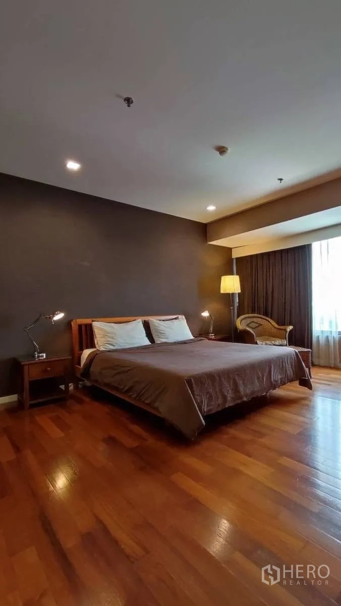 คอนโด ให้เช่าในSathon, Bangkok - ห้องนอนใหญ่พื้นไม้ ผนังสีเข้ม โคมไฟตั้งพื้น เก้าอี้หวาย และหน้าต่าง