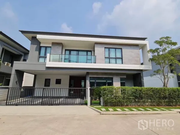 独立式住宅 出租或出售在Bang Phli, Samut Prakan - 现代两层独栋别墅，带阳台、车棚与整齐绿篱。