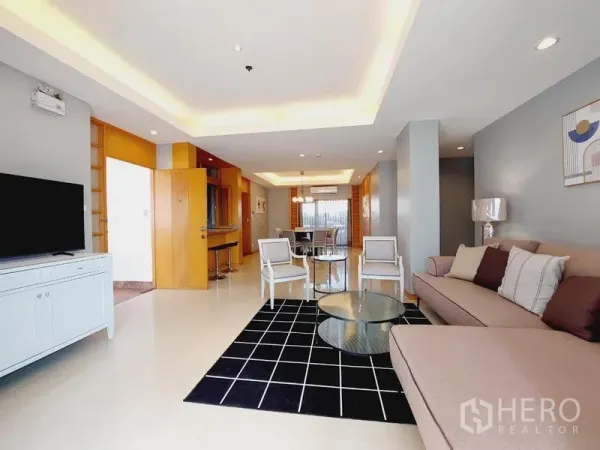 Apartment for rent - Spacious open-plan living and dining area with sofa, TV console, and recessed ceiling lights.
