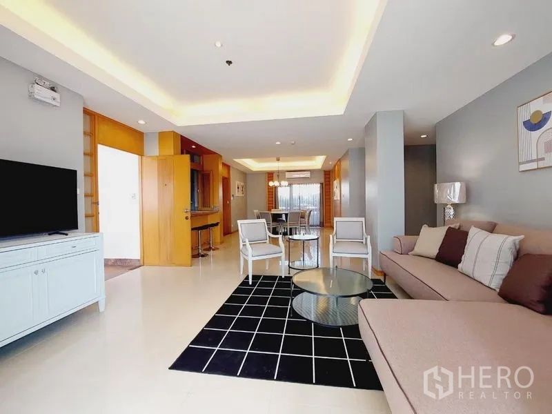 Apartment for rent - Spacious open-plan living and dining area with sofa, TV console, and recessed ceiling lights.