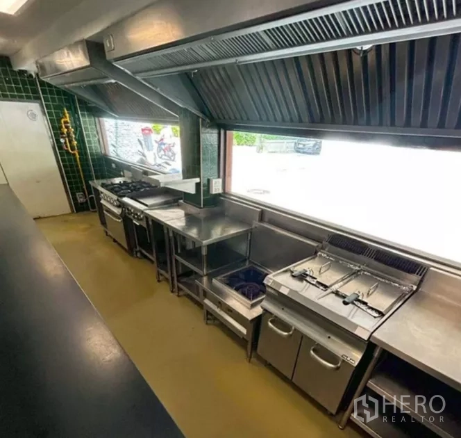 Retail Space for rent in Yan Nawa, Bangkok - Row of commercial stoves and fryers beneath a large exhaust hood in the hot kitchen line.