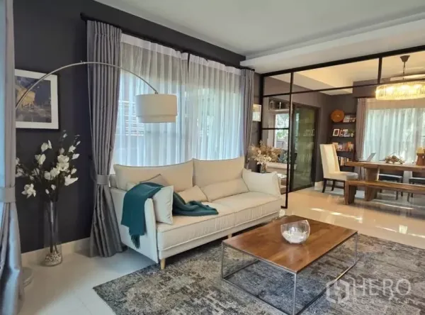 Detached House for rent in Bang Phli, Samut Prakan - Bright living room with cream sofa, floor lamp, sheer curtains and a wooden coffee table
