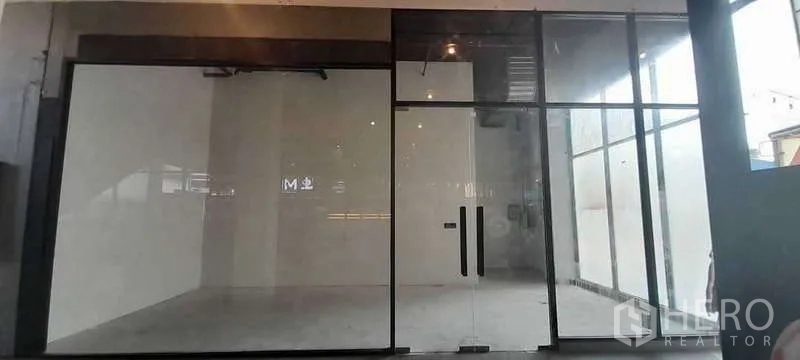 零售空间 出租 - 空置街铺，通高玻璃立面与双开玻璃门，白色墙面与水泥地面，可即刻装修，位于曼谷萨通区。