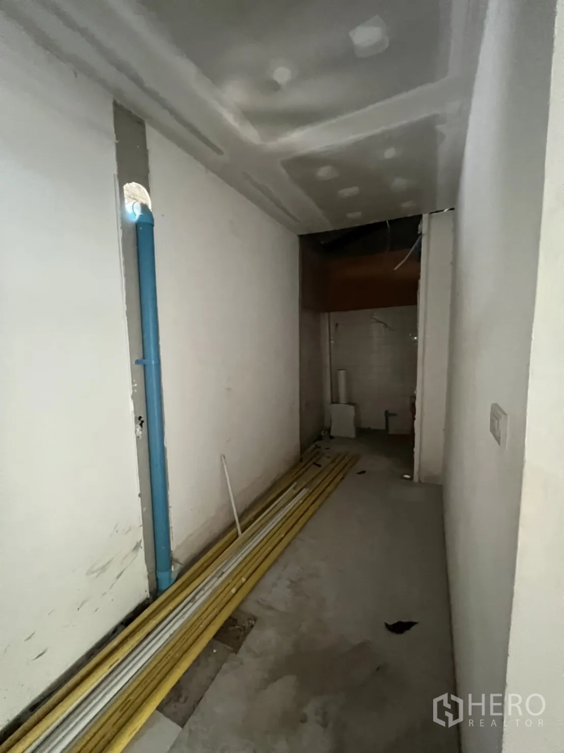店屋 出租在Watthana, Bangkok - 狭长的服务走道，外露管线与施工材料。