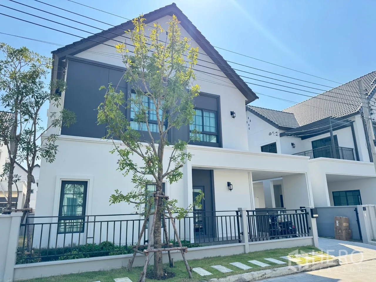 Detached House for rent in Bang Phli, Samut Prakan - Contemporary two-storey house facade with fence, lawn and young trees.