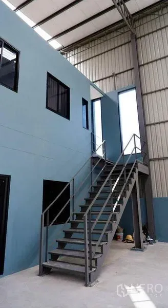 Warehouse for rent in Bueng Kum, Bangkok - Steel staircase leading to a mezzanine office inside the high-ceiling warehouse.
