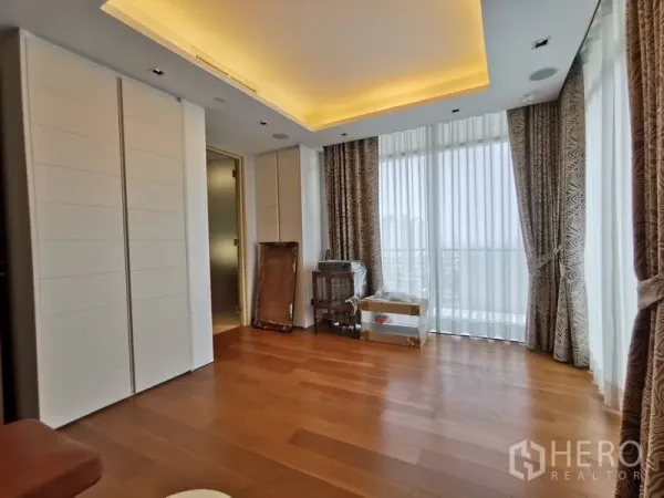 Condominium for rent or sale in Phaya Thai, Bangkok - Bedroom with full-height windows, ample wardrobes, and soft cove lighting.